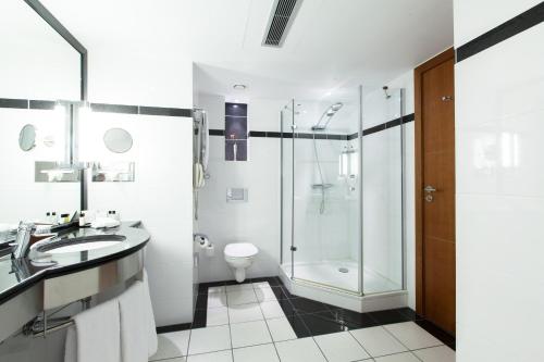 a bathroom with a glass shower and a toilet at Crowne Plaza Brussels Airport by IHG in Zaventem