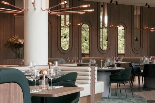 a restaurant with tables and chairs and windows at Crowne Plaza Brussels Airport by IHG in Zaventem