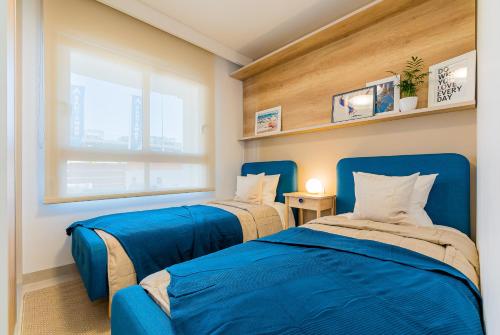 Duas camas azuis num quarto com uma janela em High class 2 Bedroom Apartment with underfloor heating em La Horadada