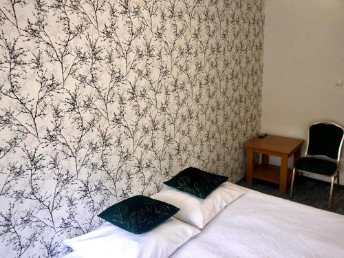 a bedroom with a bed with a black and white wallpaper at Sosnowe Zacisze in Białystok