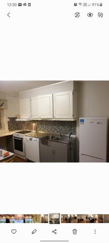 a kitchen with white cabinets and appliances at Honningsvåggt. 3H Apartement in Vardø
