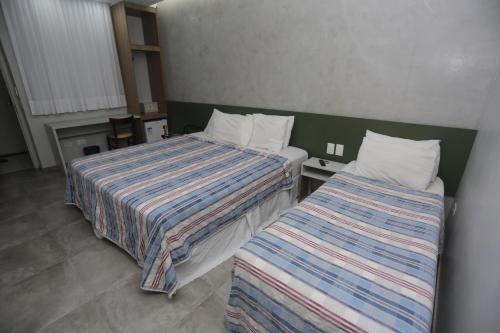 A bed or beds in a room at Rede Andrade Navegantes