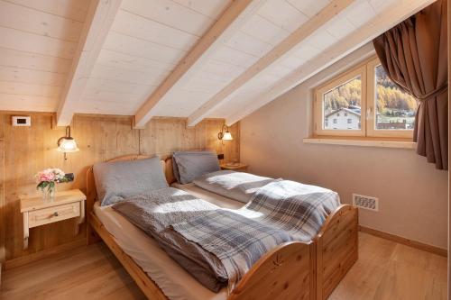 Schlafzimmer mit einem Bett und einem Fenster in der Unterkunft Appartamento Livigno in Livigno