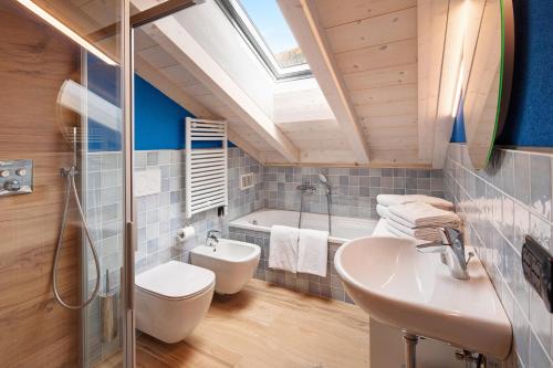 Appartamento Livigno في ليفينو: حمام مع مغسلة ودش وحوض استحمام