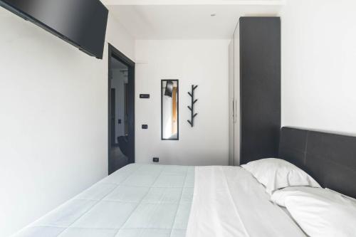 1 dormitorio con cama blanca y cabecero negro en Cozy Apartment TAM, en Bari