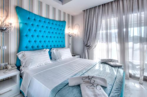 a bedroom with a large bed with a blue headboard at Art Boutique in Pefkochori