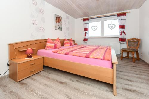 a bedroom with a bed and a chair and a window at Ferienwohnungen im Landhaus Oldenhof in Stedesdorf