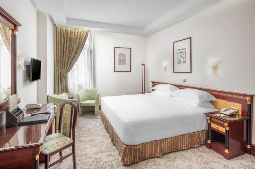 A bed or beds in a room at Al Shohada Hotel