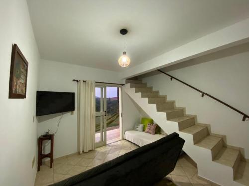 un salon avec un escalier et un canapé dans l'établissement Recanto da Tuca, à Socorro