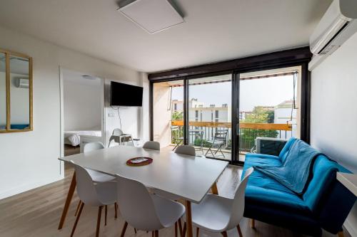 - un salon avec une table blanche et un canapé bleu dans l'établissement Ombeline, à Saint-Cyprien