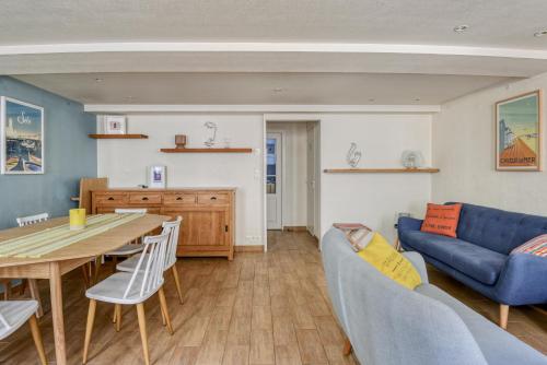 un salon avec une table et un canapé bleu dans l'établissement Sea You Soon, à Langrune-sur-Mer