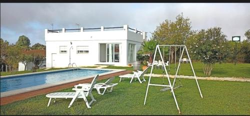 a house with a swimming pool and a swing at Joju in Sanlúcar la Mayor