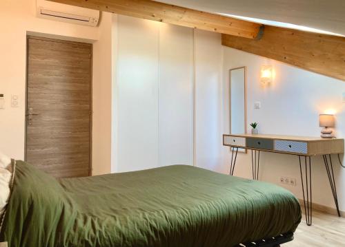 a bedroom with a green bed and a desk at T3 Sur les Toits de Propriano in Propriano