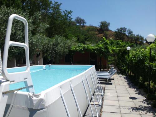 una piscina in un cortile con due panchine di Il Vigneto "Cottage" a Gaggi