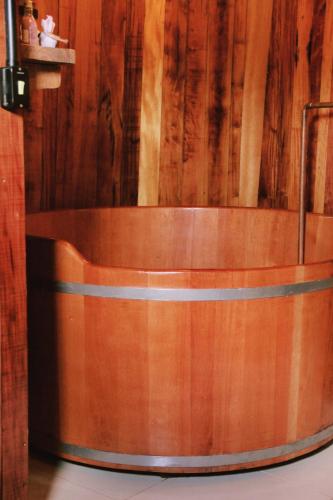 a wooden tub in a room with a wooden wall at Pousada Botte di Vino in Garibaldi