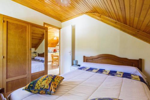 une chambre avec un grand lit avec un plafond en bois dans l'établissement Le Haut Mont-Dore, à La Bourboule