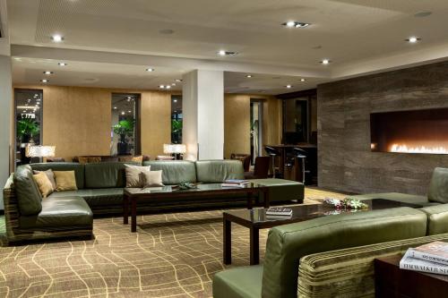a living room with green couches and a fireplace at Amsterdam Marriott Hotel in Amsterdam
