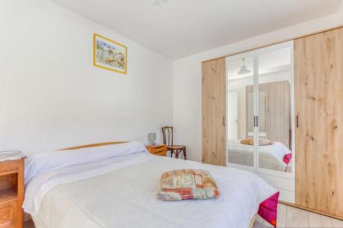 a bedroom with a white bed and a mirror at Le Bas Mont-Dore in La Bourboule