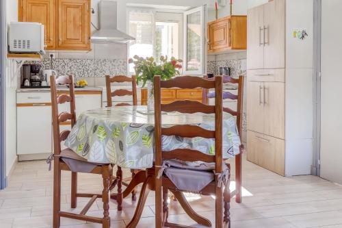 une cuisine avec une table et des chaises dans une pièce dans l'établissement Le Bas Mont-Dore, à La Bourboule