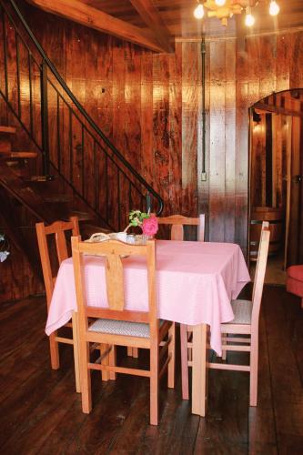 a dining room table with a pink table cloth and chairs at Pousada Botte di Vino in Garibaldi