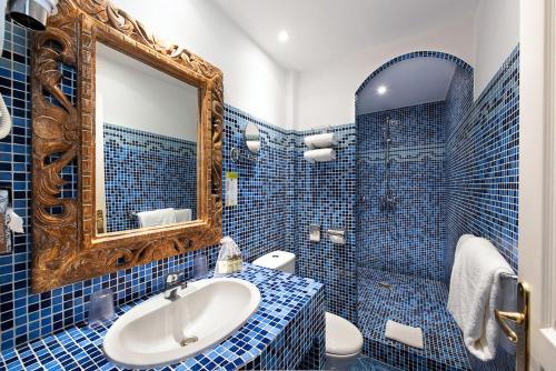 カンヌにあるオテル　シャトー　ド　ラ　トゥールの青いタイル張りのバスルーム(シンク、鏡付)