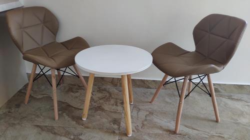 two chairs and a white table and a table at Altrude By The Sea in Candolim