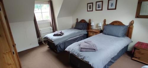 1 dormitorio con 2 camas y ventana en Ben Lomond Cottage, en Arrochar