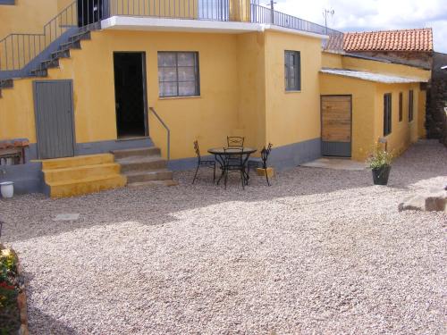 a patio in front of a yellow house with a table at casa thocamalu's in Covelo