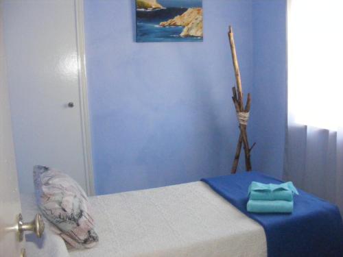 a bedroom with a bed with a blue wall at casa thocamalu's in Covelo