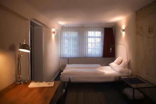 1 dormitorio con 2 camas, escritorio y ventana en Haus Oberscholtes, en Grünberg