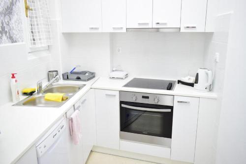 a white kitchen with a sink and a stove at Beautiful Renovated Flat in Athens (The Dem Flat) in Athens