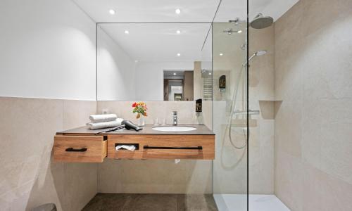 a bathroom with a sink and a glass shower at Hotel Seeblick in Obing