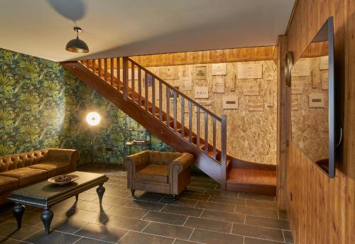 a living room with a staircase and a couch and a table at CASA RURAL ENTREVIÑAS in San Bernardo