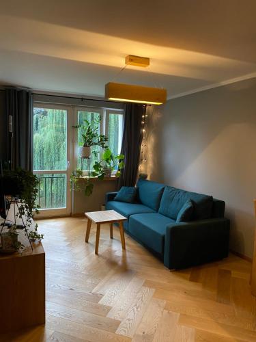 a living room with a blue couch and a table at Apartament Krakowska in Bochnia