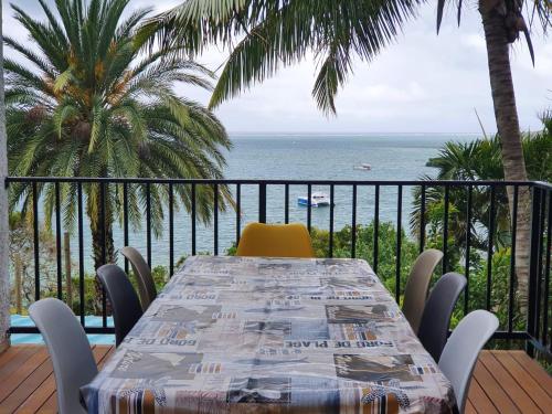 a table with a yellow chair and a view of the ocean at Family apartment with sea view - 140 m² in Trou d'Eau Douce in Trou dʼ Eau Douce