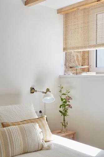 a bedroom with a bed with a lamp and a window at La casita de Canido in Oya