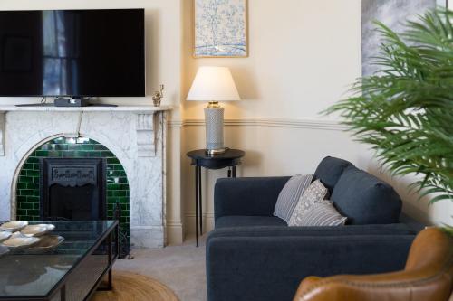 a living room with a blue couch and a fireplace at Priestley House City Centre-Free Parking in York