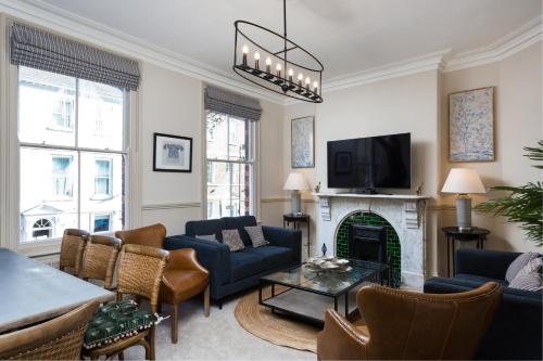 a living room with blue furniture and a fireplace at Priestley House City Centre-Free Parking in York