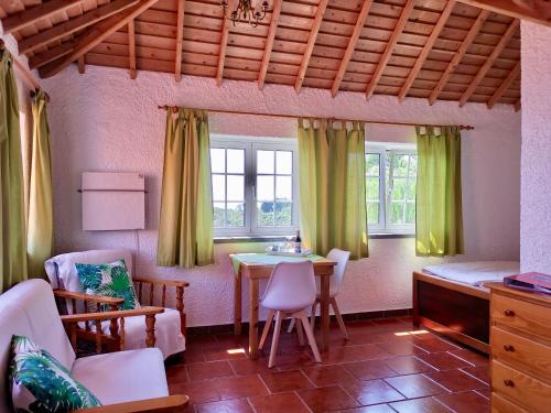a living room with a table and chairs at Vivenda Flores - Apartment Hibisco in Lomba