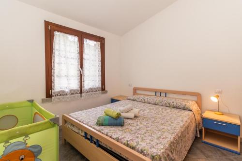 Habitación pequeña con 2 camas y ventana en Appartamento con piscina 14, en Trinità dʼAgultu