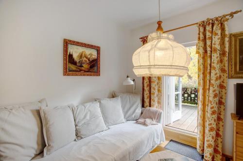 a living room with a white couch and a window at Seeberg - Haus Annamirl in Bayrischzell