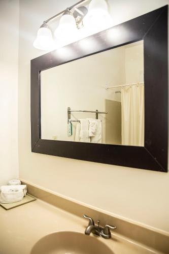 a mirror above a sink in a bathroom at Orange Hill Beach Inn in Nassau