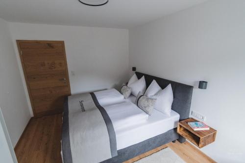 a bedroom with a bed with white sheets and pillows at Apartment Edith in Telfes im Stubai