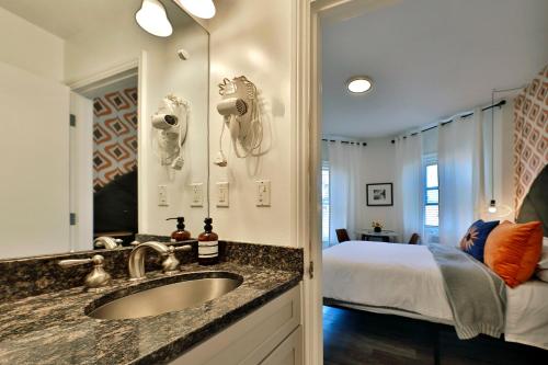 un bagno con lavandino e una camera con letto di Good Hotels Boston a Boston