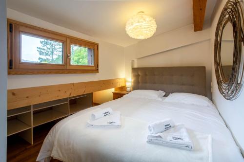 una camera da letto con un letto e due asciugamani di Neige Apartment - Chamonix All Year a Chamonix-Mont-Blanc