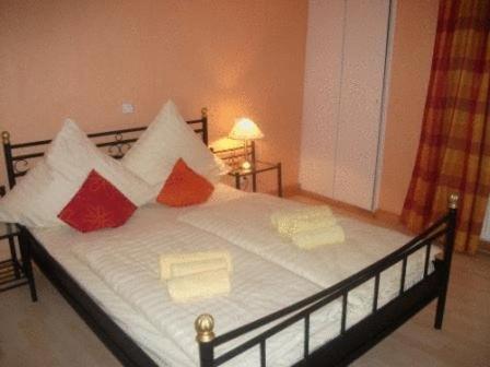 a bed with red and white pillows on it at Hotel Hirsch Garni in Fulda