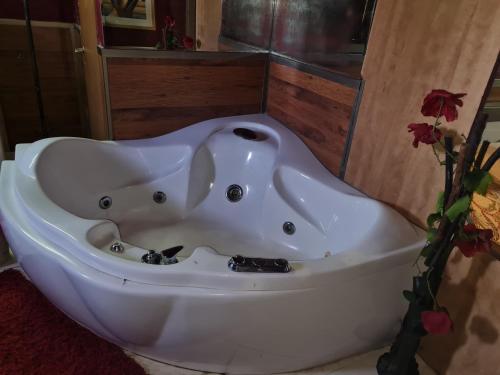una vasca da bagno bianca seduta in bagno di vacation house יחידת אירוח פרטית הוד השרון a Hod HaSharon
