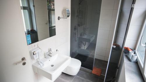 y baño blanco con lavabo y ducha. en OMAS-STUBB-das-Komfort-DZ-mit-Balkon-im-Herrenhaus, en Marktheidenfeld