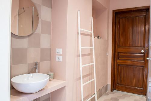 a bathroom with a white sink and a mirror at Florence Trevelyan Villa in Letojanni