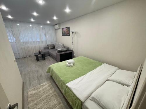 a bedroom with a green bed and a couch at Sun City apartment 1 in Sochi